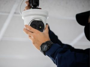 Tecnico installa una telecamera di videosorveglianza a soffitto, parte di un impianto TVCC professionale per la sicurezza di case, negozi e aziende a Napoli.