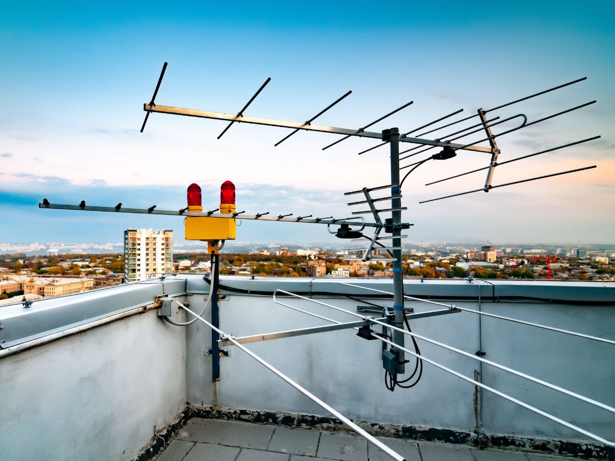 Antenna centralizzata installata sul tetto di un condominio con vista su Napoli, utilizzata per la distribuzione del segnale televisivo.